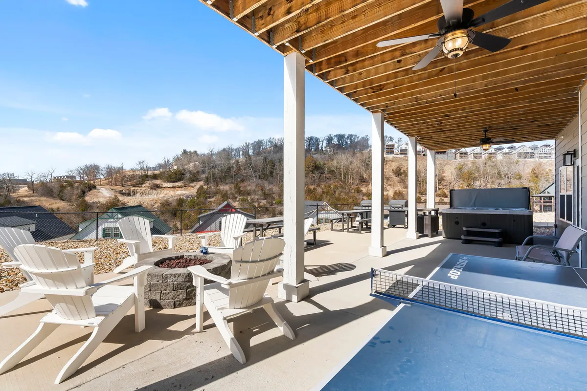 This exterior shot captures an outdoor seating area with a hot tub, a ping pong table, and views of the surrounding landscape. The space is designed for both relaxation and active fun, with areas for socializing and unwinding—a natural extension of the lodge’s entertainment amenities.