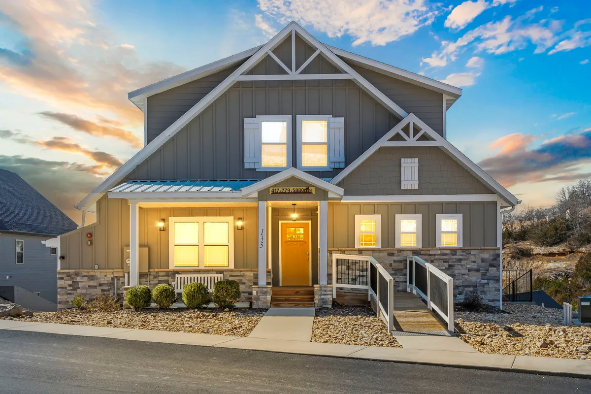 The front entrance of the lodge, featuring large windows and a stone facade. The inviting pathway and well-maintained exterior suggest a warm welcome for all guests, including those with pets.