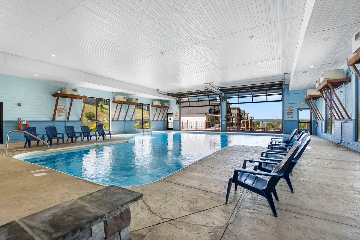 This interior photograph captures the community’s indoor swimming pool, featuring tranquil blue waters, rows of comfortable lounge chairs, and large windows that fill the space with natural light. The serene atmosphere is ideal for relaxation or year-round swimming, regardless of the season.